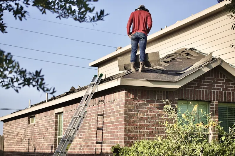 Professional roofer working on a residential roof in Arvada Plaza Area
